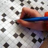Child holding a pencil, writing inside a crossword puzzle, part of our #kidsprintablecrosswordpuzzle collection